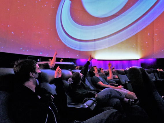 class pointing at planetarium ceiling flandrau