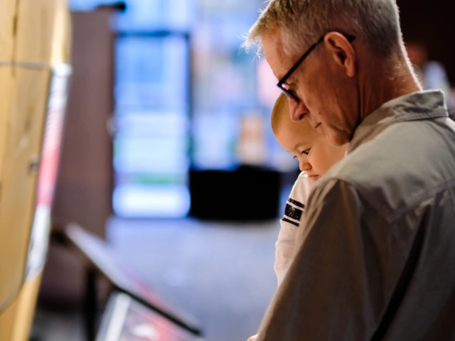 A grandparent and toddler look at science exhibits at Flandrau planetarium in Tucson