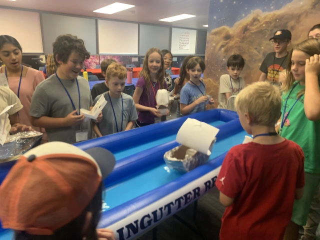 Children gather around an engineering activity